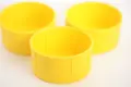 Close up of three yellow plastic scaffold protection caps showing internal ribs.