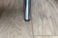 A chrome metal tube. Fitted with a black plastic round tube insert with a domed top, in the end of the tube.