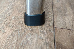 An oval metal chair leg with a black LDPE chair foot mounted to the base.