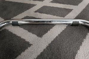 Close up of black plastic saddle feet fitted to chrome tube cantilever chair base.