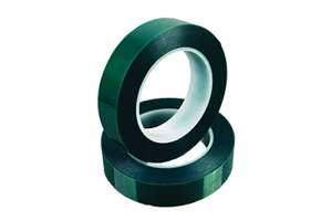 Two rolls of green polyester masking tape. One on its side and the other standing on top of it.