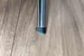 Top-down view of a round black LDPE injection-moulded foot insert fitted to the end of a metal tube leg, with a felted angled base profile visible.