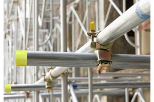 Close up of scaffolding construction including clamps and protection caps.