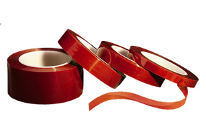 Four rolls of red silicone self fusing tape. Leaning against each other at an angle.