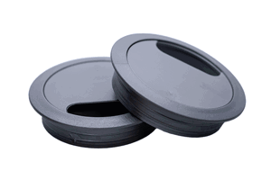 Grey plastic desk grommets stacked on each other with plain background.