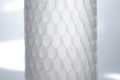 Clear plastic protective bottle netting, stretched over a tube.