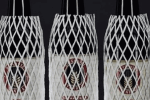 Three bottles of wine, covered in white plastic protective netting.