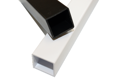 A close up of Two extruded plastic square tubes, in black and white. One laying across the other.