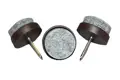 Three nail in feet. Grey felt on brown plastic base with metal nail.