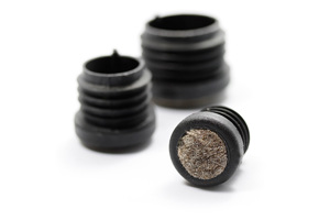 Side view of three round black plastic tube inserts with flat anti-scratch felted bases designed to protect floors.