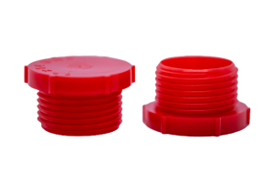 Two red plastic BSP threaded plugs. Both standing on opposite ends.