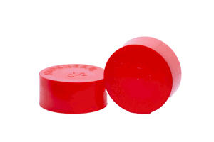 Side-by-side view of two round, red, LDPE injection moulded protective caps—one face down to show the STOCKCAP logo embossed on the closed end, and one on its side facing forward.