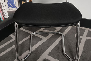 Cantilever chair showing two plastic saddle feet fitted to chrome tube chair base.