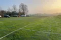 A temporary car park with grass growing through the plastic mesh and lines painted on top.