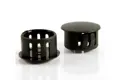 Two black plastic blanking plugs. Both standing up, showing opposite ends.