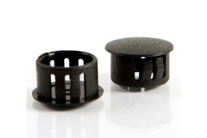 Two black plastic blanking plugs. Both standing up, showing opposite ends.