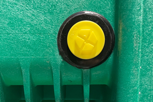 A yellow plastic Metric threaded plug with a sealing washer. Fitted to a green plastic product.