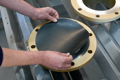 Collection of flange plates with rubber protective disc being placed in centre.