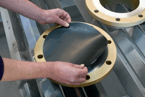 Collection of flange plates with rubber protective disc being placed in centre.