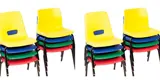 Multiple colours stacked primary school chairs in a row.