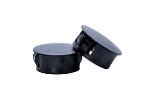 Two black plastic blanking plugs. One standing up, one at an angle.